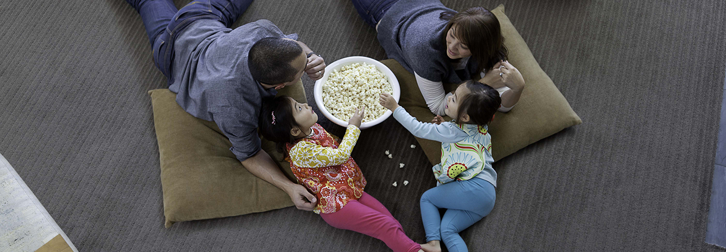 Family eating popcorn on Stainmaster carpet.